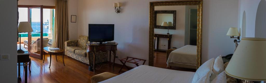 a hotel room with a bed and a television at Diva La Canzone Del Mare in Capri