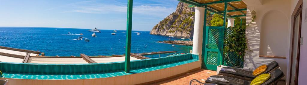 a room with a view of the ocean from a balcony at Diva La Canzone Del Mare in Capri