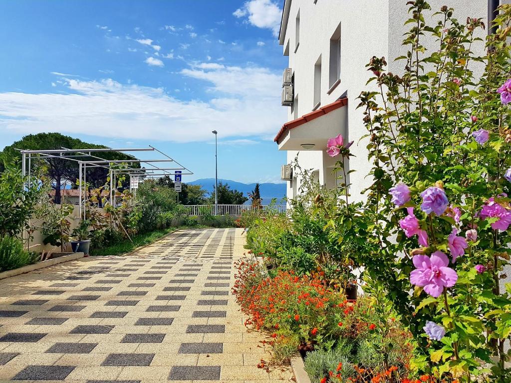 a garden with flowers next to a building at Apartment Milka 1 in Njivice