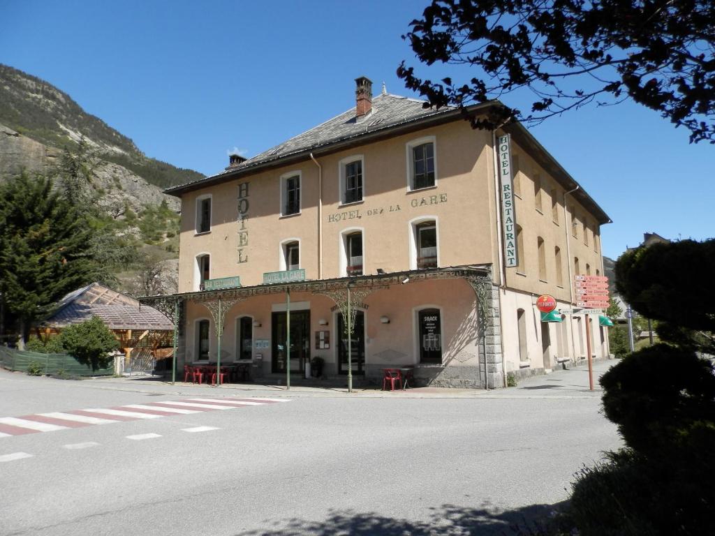 a large building on the side of a street at Hotel La Gare in LʼArgentière-la-Bessée