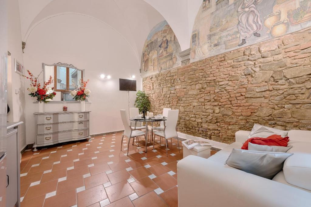 sala de estar con sofá blanco y pared de piedra en Santo Spirito Frescos, en Florencia