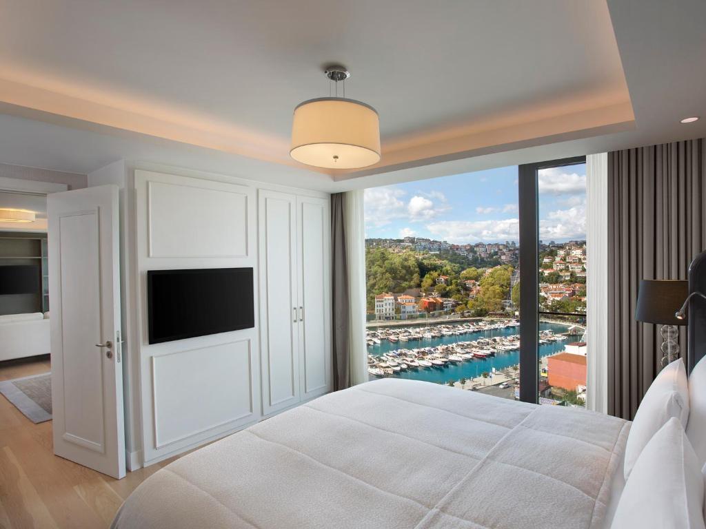 a bedroom with a large window with a view of a harbor at The Grand Tarabya Managed by Accor in Istanbul