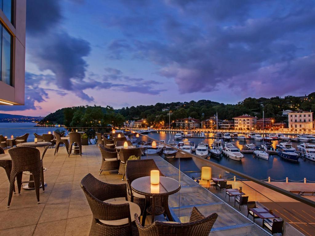 a restaurant with a view of a marina at night at The Grand Tarabya Managed by Accor in Istanbul