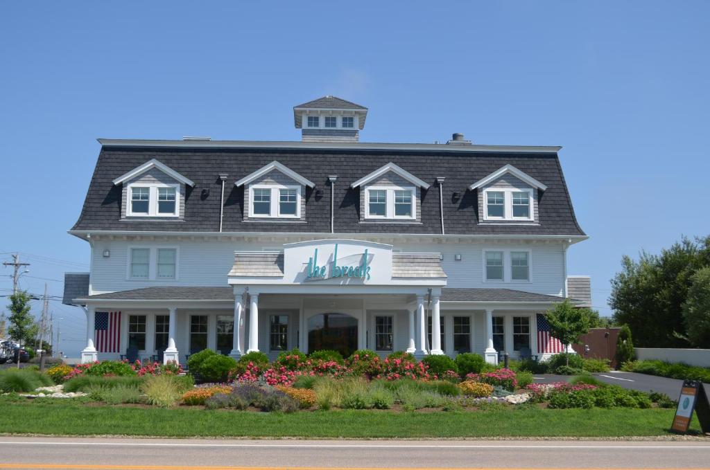 une maison blanche avec un toit noir dans l'établissement The Break Hotel, à Narragansett