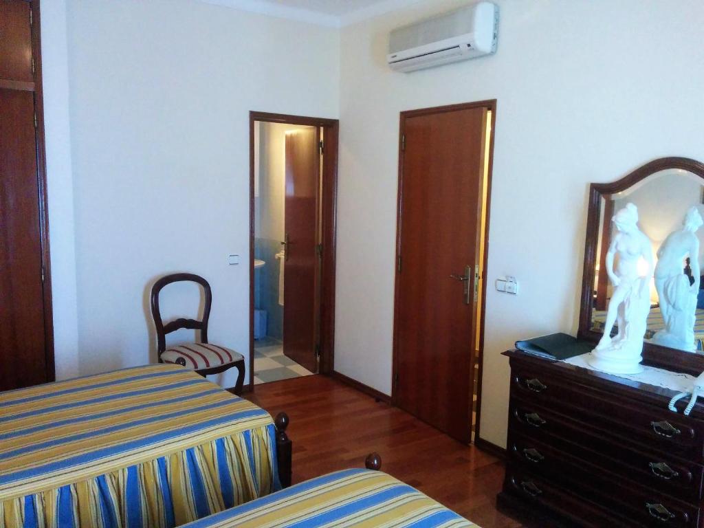 a bedroom with a bed and a dresser and a mirror at Hospedaria A Varanda in Alvito