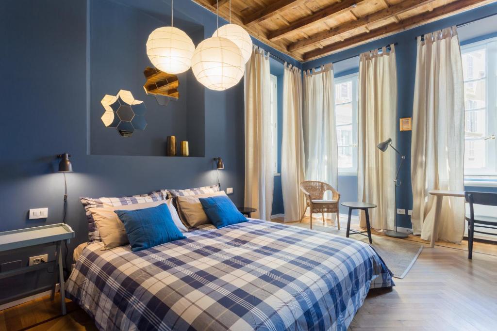 una camera blu con un letto e pareti blu di COSY APARTMENT 2 MINUTES FROM DUOMO a Milano