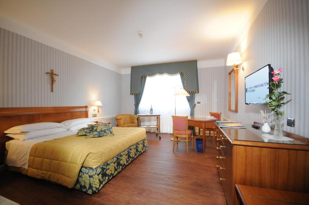 a hotel room with a bed and a desk at Hotel Centro di Spiritualità Padre Pio in San Giovanni Rotondo