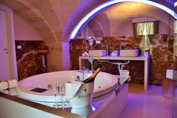 a large bathroom with a tub with a bottle of champagne at B&B Sul Ponte in Gravina in Puglia