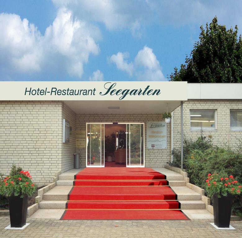 eine rote Treppe mit Teppichboden, die zu einer Hotelrezeption führt in der Unterkunft Hotel-Restaurant Seegarten Quickborn in Quickborn
