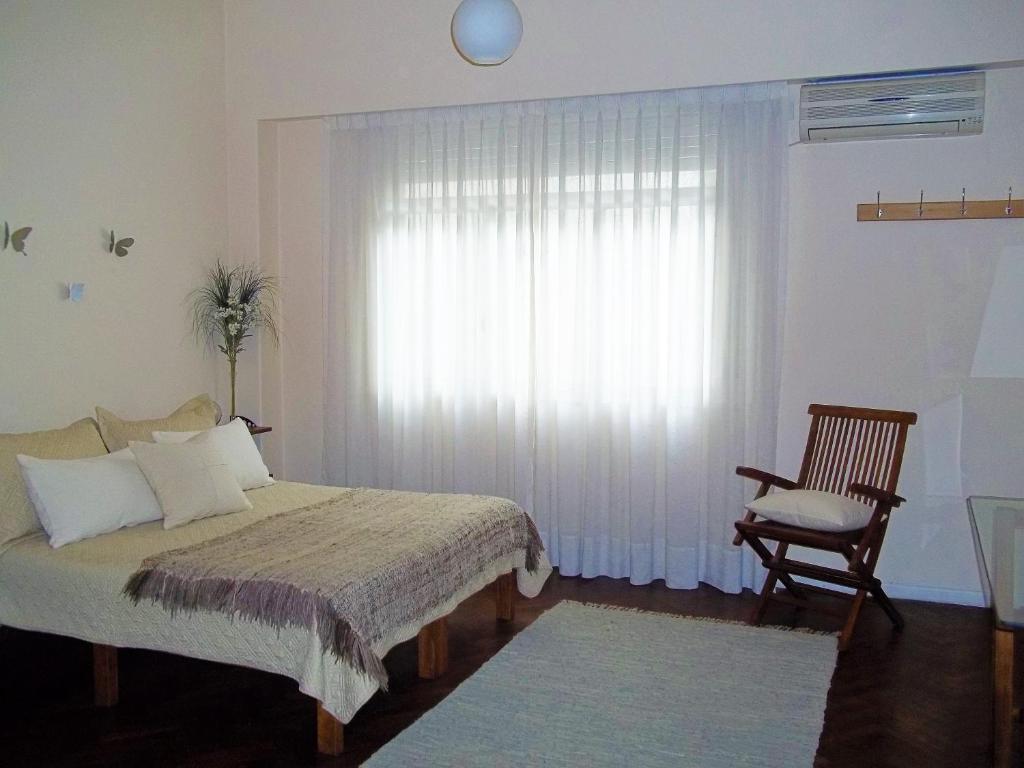 1 dormitorio con 1 cama, 1 silla y 1 ventana en Departamento Posadas en Buenos Aires