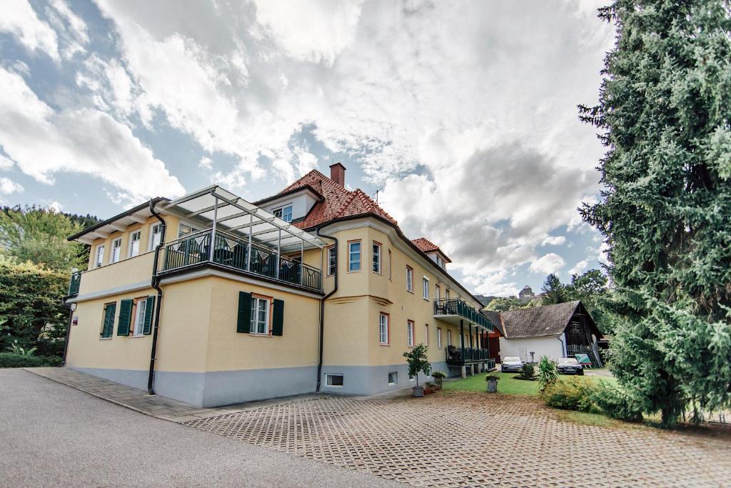 ein großes gelbes Haus mit Dach in der Unterkunft Gästehaus Kleindienst in Deutschlandsberg