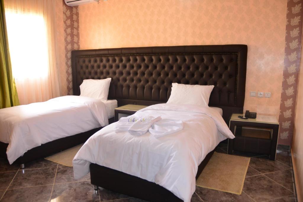 Una cama o camas en una habitación de Hôtel Hadaik Ain Asserdoune