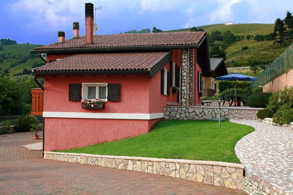uma pequena casa vermelha com um jardim verde em Bed and Breakfast Eckele em Conco