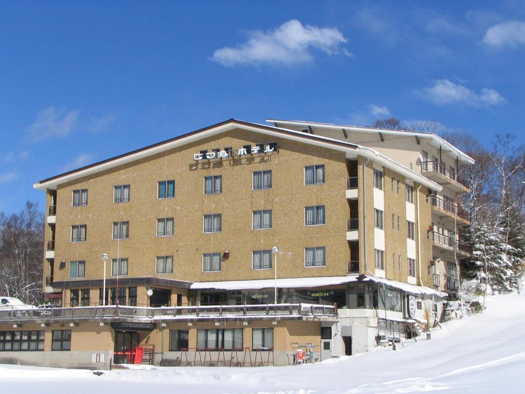 a large building with snow in front of it at Biwaike Hotel in Yamanouchi
