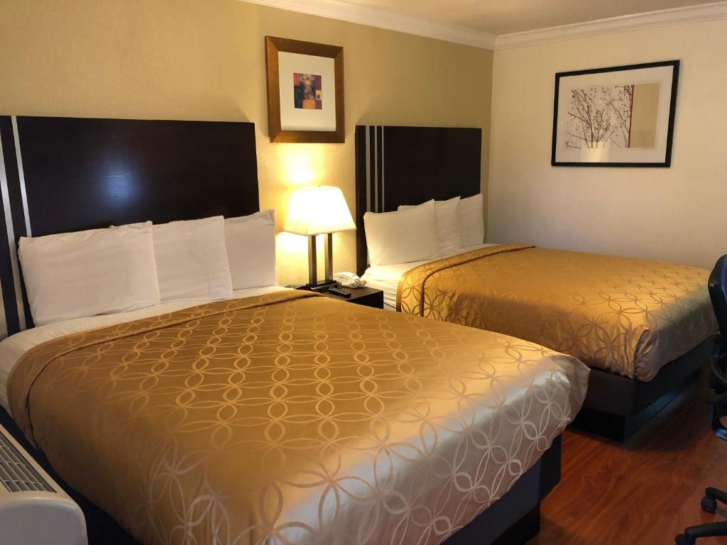 a hotel room with two beds and a lamp at Lombard Plaza Motel in San Francisco