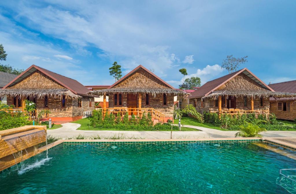 une maison avec une piscine en face de deux bâtiments dans l'établissement Pinthong Aonang Villa - FREE SHUTTLE SERVICE TO THE BEACH, à Ao Nang Beach