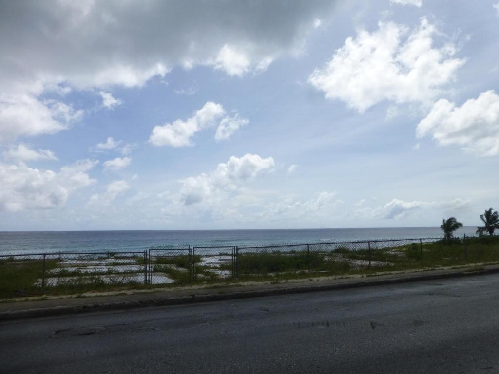 a road with a view of the ocean on a cloudy day at Hastings Towers 3B Opp Sea 2 Bed 2 Bath in Bridgetown