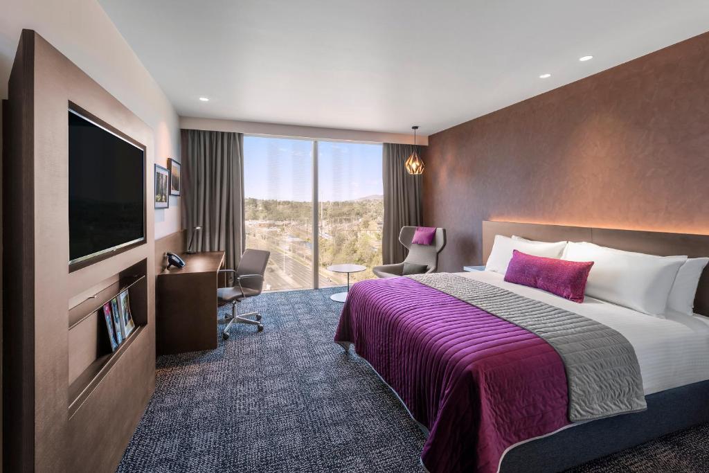 a hotel room with a bed and a flat screen tv at Sage Melbourne Ringwood in Ringwood