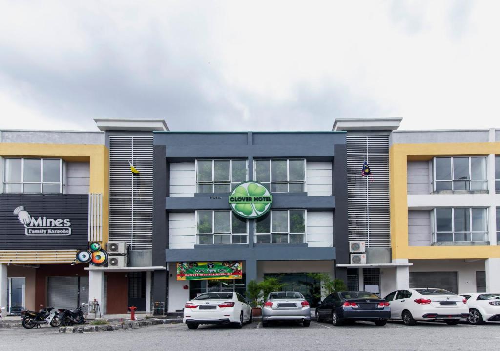 a building with cars parked in a parking lot at Clover Hotel Ipoh in Ipoh
