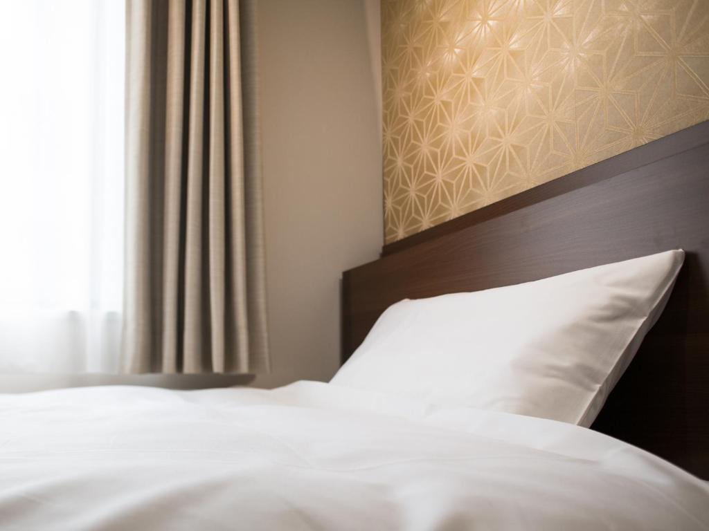 Postel nebo postele na pokoji v ubytování Tosei Hotel Cocone Kanda