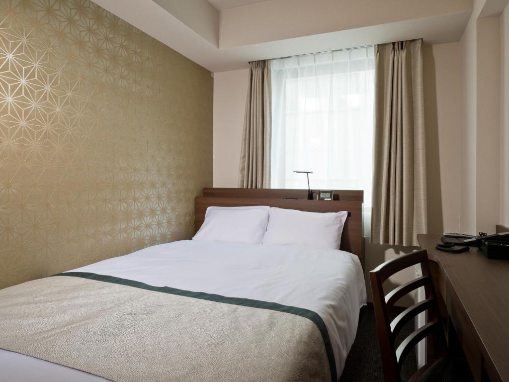 Postel nebo postele na pokoji v ubytování Tosei Hotel Cocone Kanda