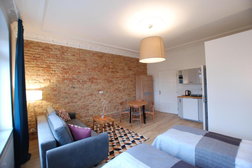 a living room with a couch and a brick wall at Apartamenty 21 in Szczecin