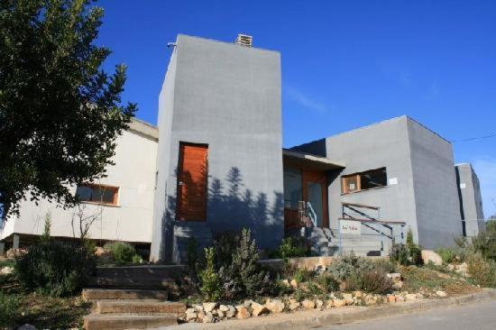 Una casa blanca con un árbol delante. en La Aldea en Calles