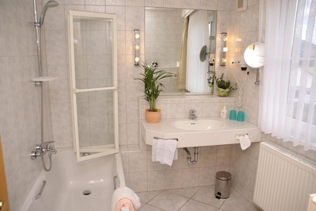 a bathroom with a sink and a shower and a toilet at Hotel zum Schiffchen in Wolfhagen