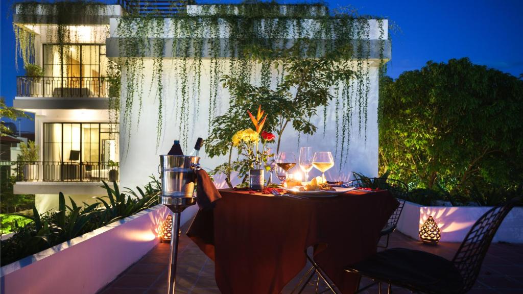 a table with glasses and lights on a balcony at night at Vihara The City of Temples in Siem Reap
