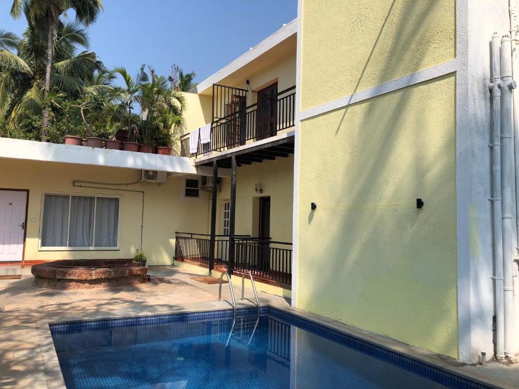 a view of a building with a swimming pool at Banyan Tree Courtyard in Candolim