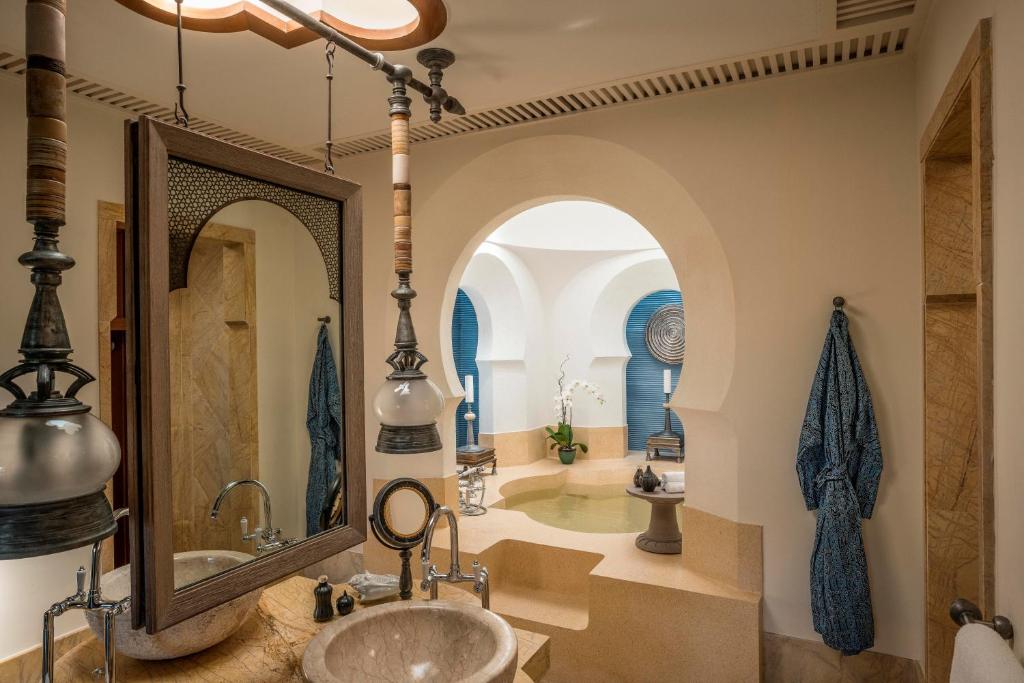 a bathroom with a tub and a sink and a mirror at Four Seasons Resort Langkawi in Tanjung Rhu