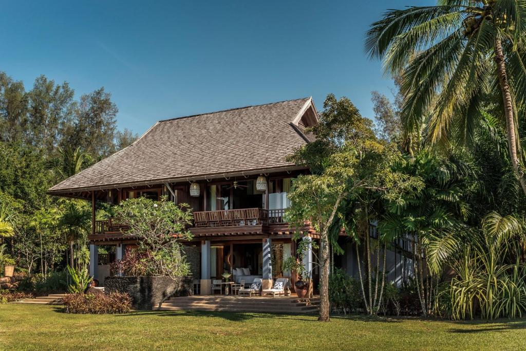 a house with palm trees in front of it at Four Seasons Resort Langkawi in Tanjung Rhu