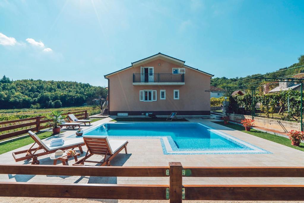 a villa with a swimming pool in front of a house at Villa Zen Imotski in Zmijavci
