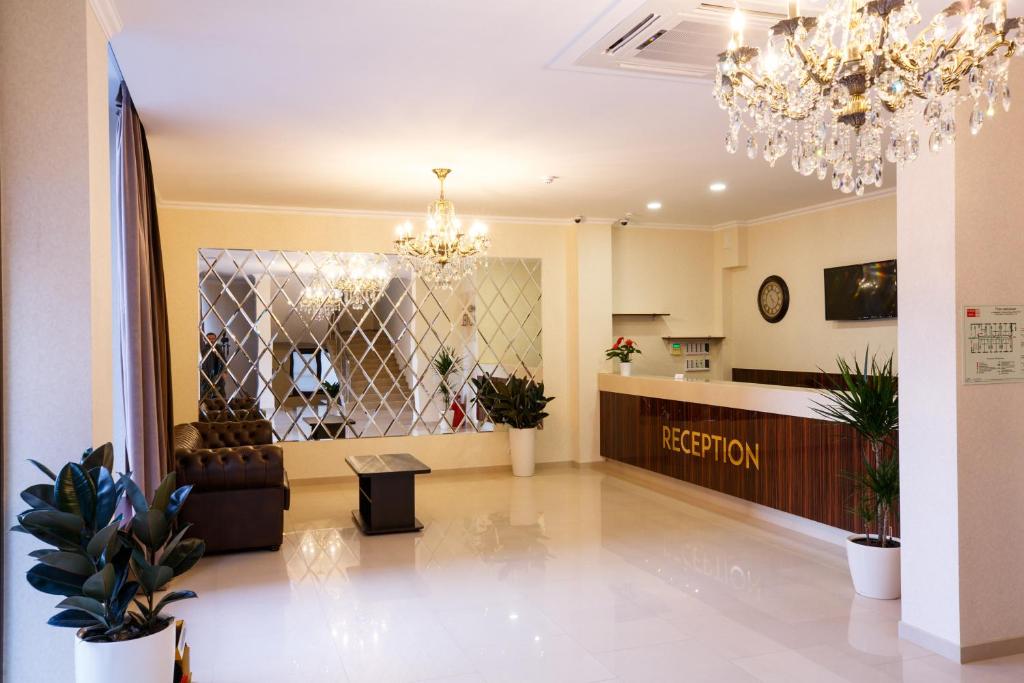a lobby with a reception area and a chandelier at Meliton Hotel in Krasnodar