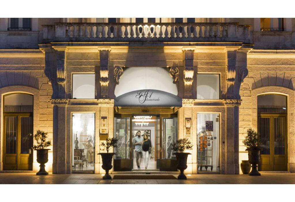 a store front of a building with people walking into it at Grande Albergo Internazionale in Brindisi