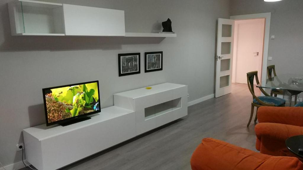 sala de estar con TV de pantalla plana en la pared en San Anton Centro Apartment, en Logroño