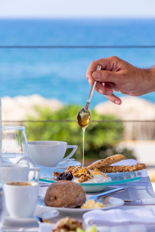 a person holding a spoon over a plate of food at Horizon Blu Boutique Hotel in Kalamata