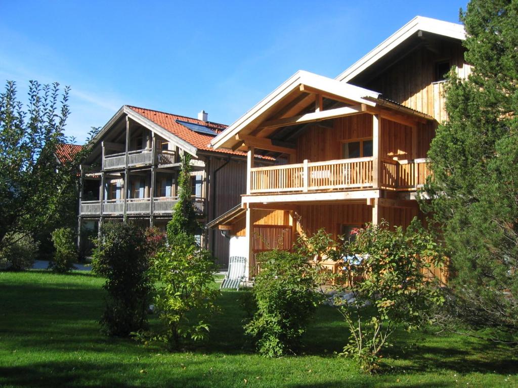 duży drewniany dom z ogródkiem w obiekcie Ferienwohnungen Evi Huber w mieście Oberammergau