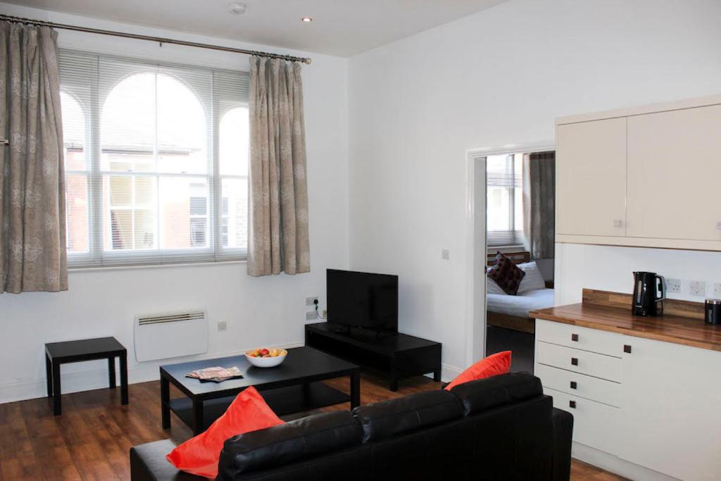 uma sala de estar com um sofá e uma mesa em Princes Dock Chambers 3 em Hull