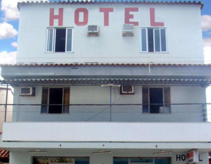 a white building with a hotel sign on it at Hotel Ximenes in Casimiro de Abreu