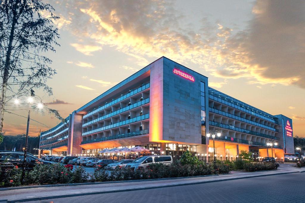 a building with a santander hotel in a parking lot at Jutrzenka Medical SPA in Włocławek