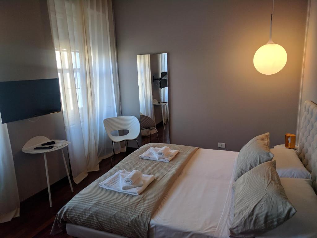 a bedroom with a bed with two towels on it at Pep's Rooms by the sea in Trieste