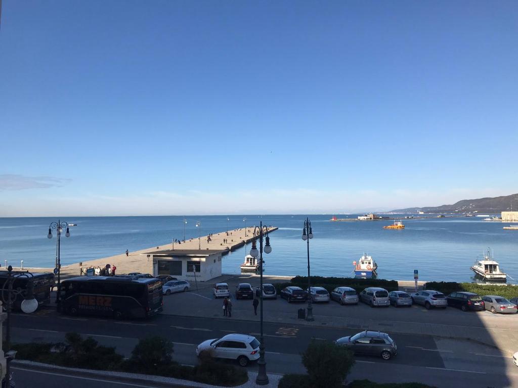a parking lot with a pier and boats in the water at Pep's Rooms by the sea in Trieste
