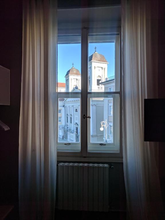 a window with a view of a building at Pep's Rooms by the sea in Trieste