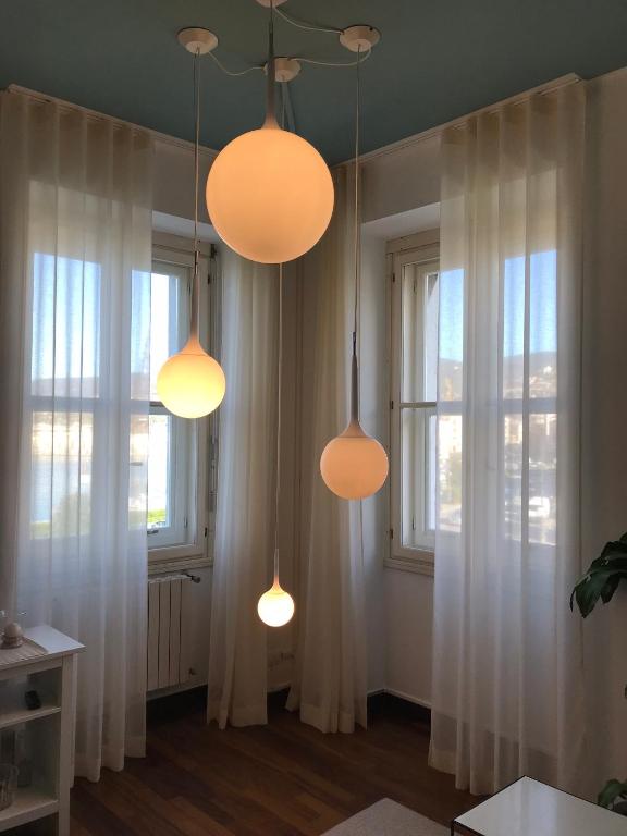 a room with three lights and two windows at Pep's Rooms by the sea in Trieste