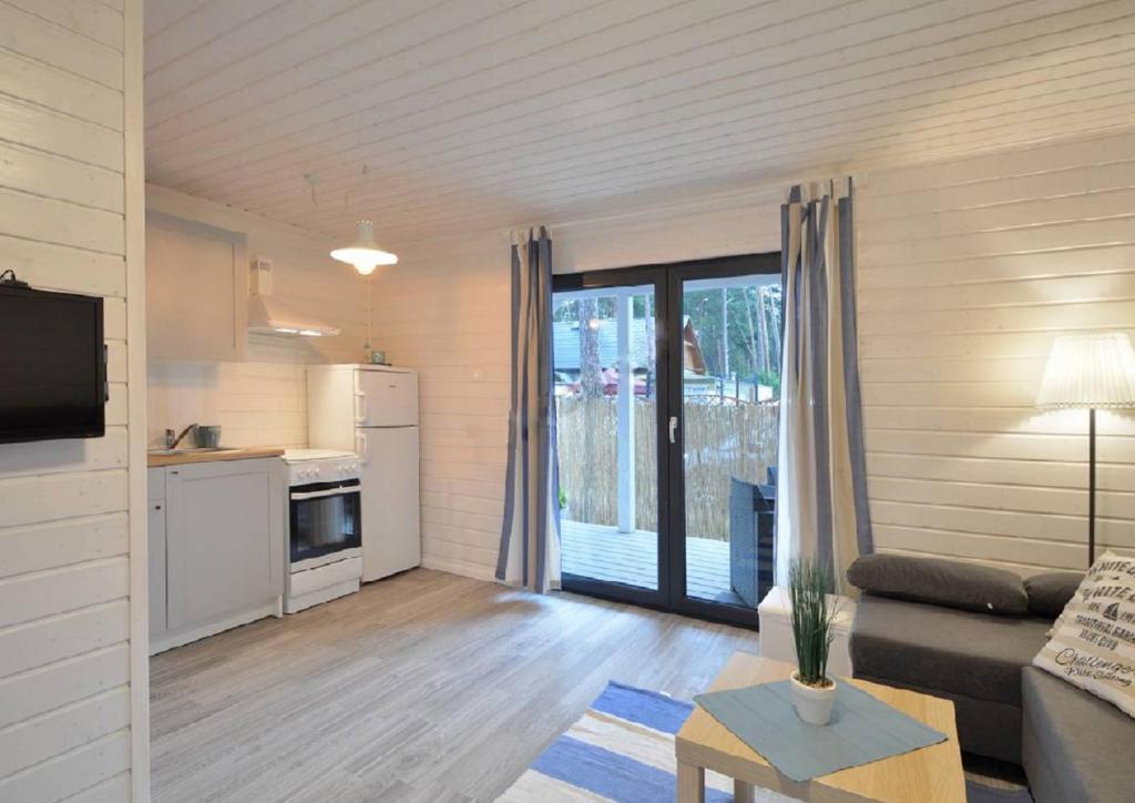 a living room with a couch and a kitchen at Villa Playa in Dziwnówek