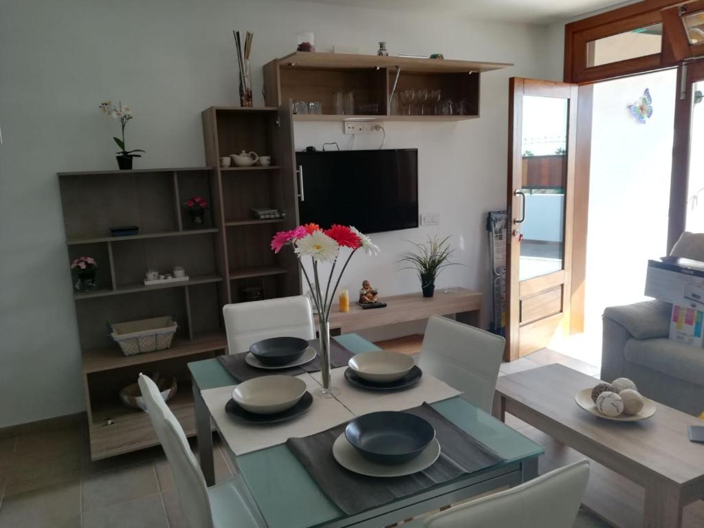 a dining room with a table and chairs and a television at Paraiso Rubicón in Tías