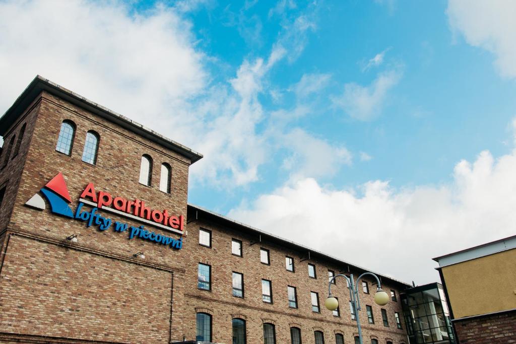 a building with a sign on the side of it at Apartamenty „Lofty w piecowni” in Włocławek