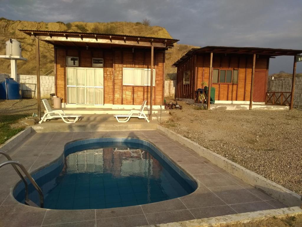 uma pequena piscina em frente a uma pequena casa em Bonanza Beach House Zorritos em Bocapán