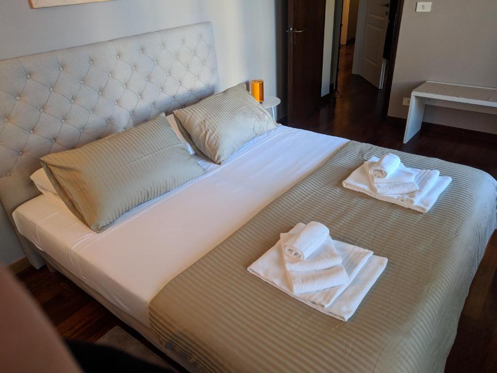 a bed with two towels sitting on top of it at Pep's Rooms by the sea in Trieste